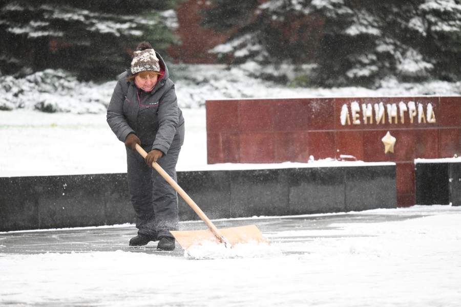 Сотрудница коммунальных служб чистит дорогу у памятника городам-героям в Александровском саду у Кремлёвской стены во время снегопада. В столичном регионе выпал первый снег. До конца дня 27 октября МЧС обещает метель, гололедицу и порывы ветра до 15 м/с