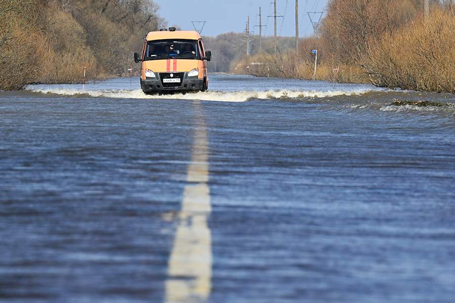 Автомобиль сотрудников ГКУ МО "Мособлпожспас" на подтопленной дороге в Луховицком районе Московской области.