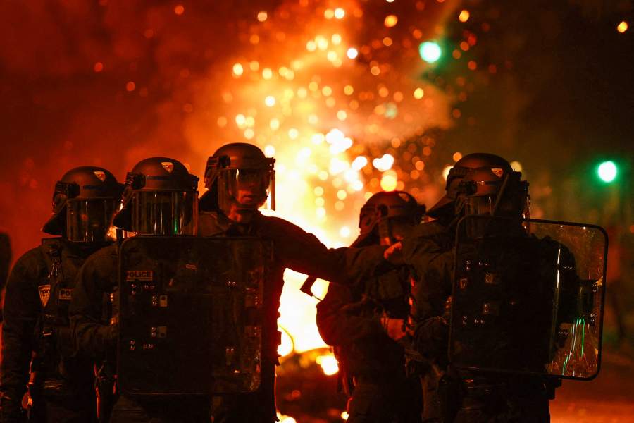 French riot police stand in position near burning bicycles during clashes with demonstrators following partial results in the second round of the early French parliamentary elections, at the Place de la Republique in Paris, France, July 7, 2024