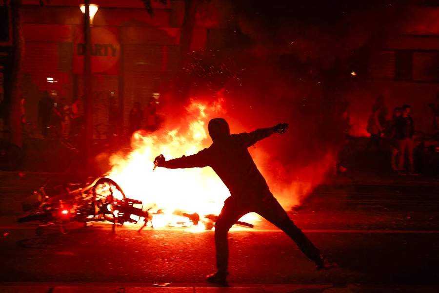 A protester throws a projectile near burning bicycles during clashes with police following partial results in the second round of the early French parliamentary elections, at the Place de la Republique in Paris, France, July 7, 2024