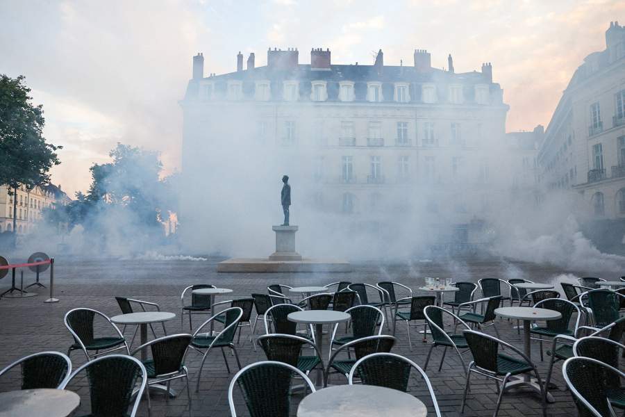 A statue is seen among tear gas following clashes during a demonstration after partial results in the second round of the early French parliamentary elections, in Nantes, France, July 7, 2024