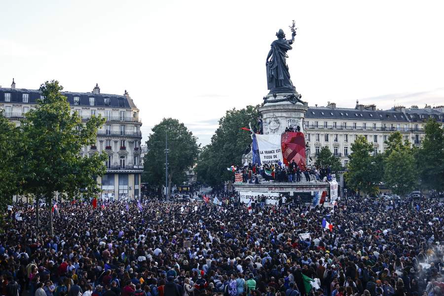 Protesters hold a giant French flag on the statue of Marianne as people gather at the Place de la Republique after partial results in the second round of the early French parliamentary elections, in Paris, France, July 7, 2024