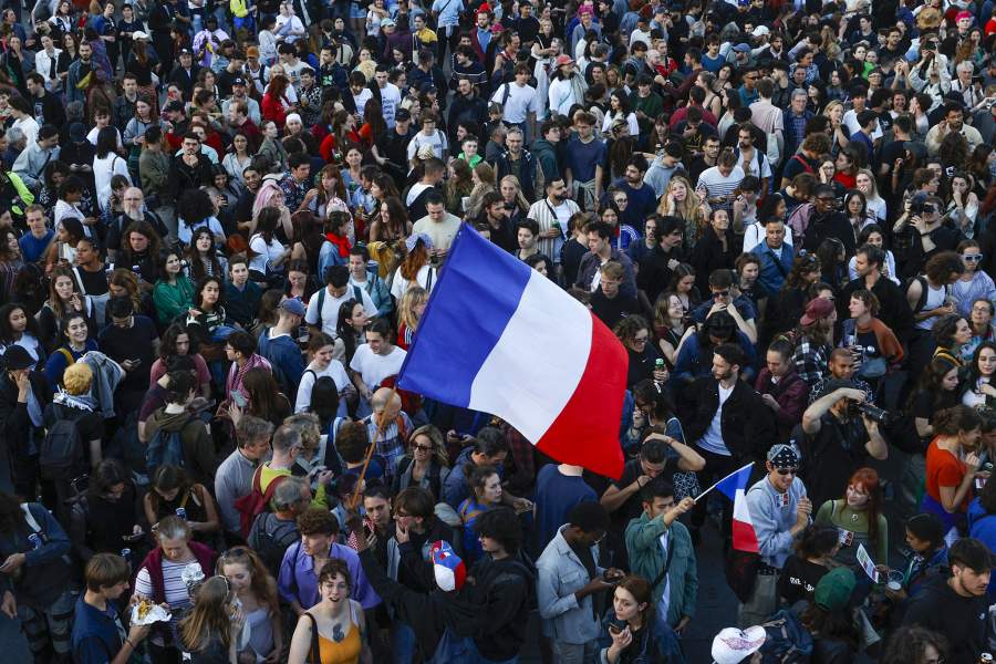 People hold French flags as they gather at the Place de la Republique after partial results in the second round of the early French parliamentary elections, in Paris, France, July 7, 2024
