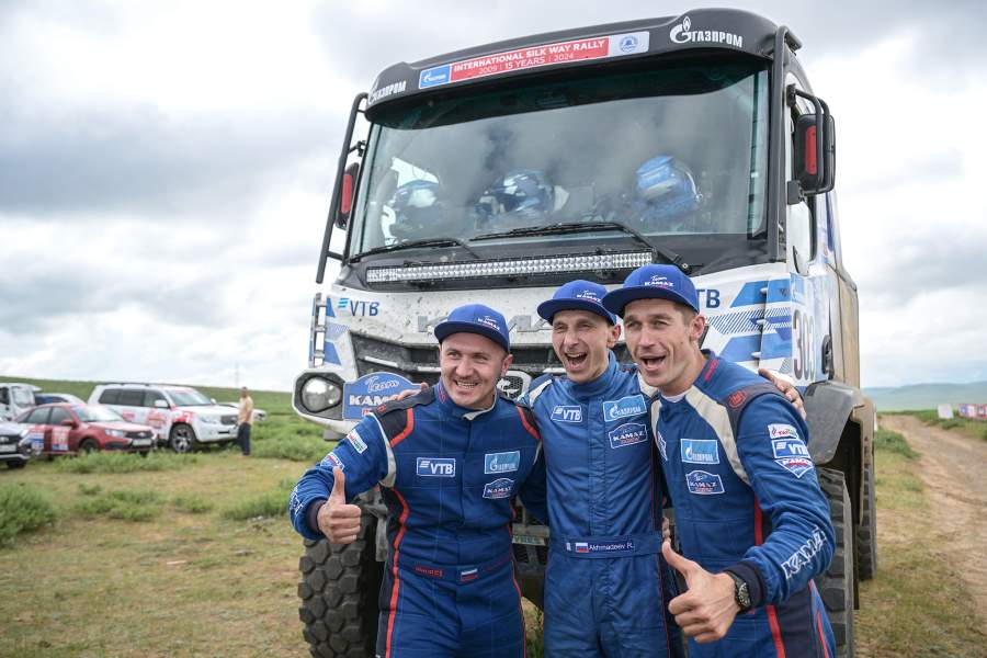 Гонщики команды «КАМАЗ-мастер» Дмитрий Сотников, Руслан Ахмадеев и Ильгиз Ахметзянов (экипаж 303) на церемонии финиша после 11 этапа ралли «Шелковый путь - 2024» Мандалгоби - Улан-Батор