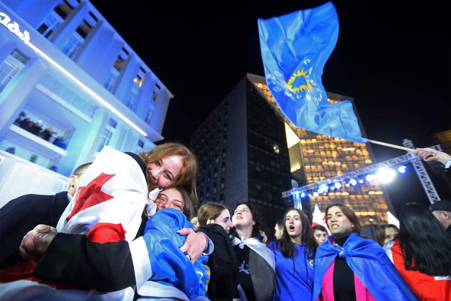 Сторонники партии «Грузинская мечта» празднуют в штаб-квартире партии после объявления результатов экзитпола на парламентских выборах в Тбилиси, Грузия