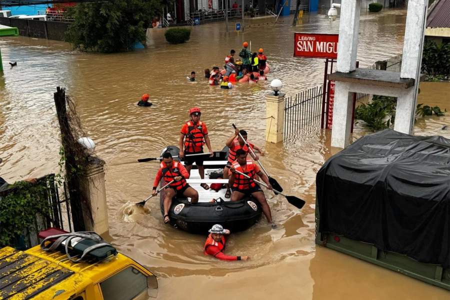 Сотрудники филиппинской береговой охраны эвакуируют жителей после того, как паводковые воды поднялись из-за проливных дождей, вызванных тропическим штормом «Трами», в Камаринес-Сур, Филиппины