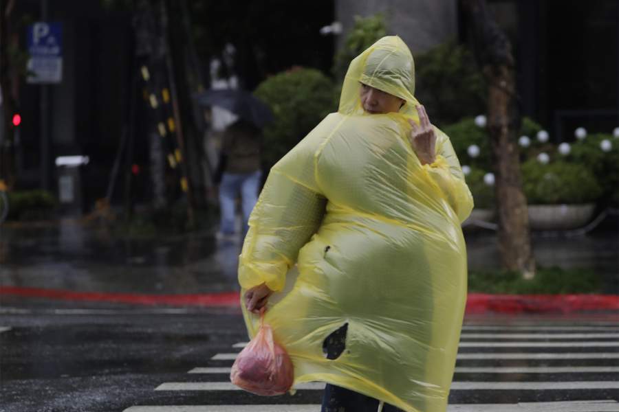 Женщина борется с ветром и дождем, вызванными тайфуном Конг-рей, в Тайбэе, Тайвань, четверг, 31 октября 2024 года