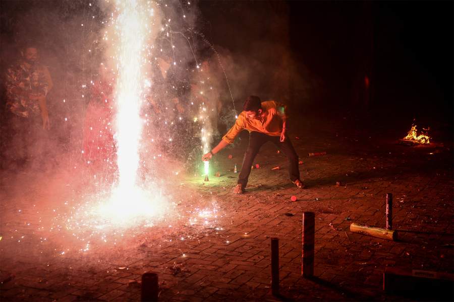 Мужчина зажигает петарду в честь Дивали, индуистского фестиваля огней, в Ахмедабаде, Индия, 1 ноября 2024 года