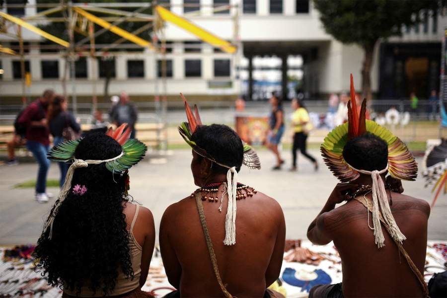 Бразильские коренные жители патаксо сидят на фестивале Глобального альянса против голода и бедности в кулуарах саммита G20 в Рио-де-Жанейро, Бразилия, 14 ноября 2024 года