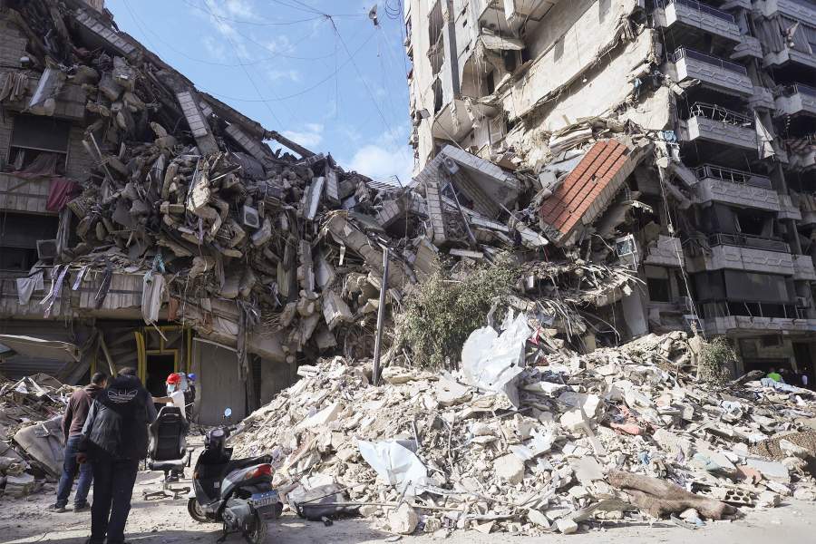 Люди разбирают завалы возле входа в здание на поврежденном участке в южном пригороде Бейрута после прекращения огня между Израилем и Хезболлой, Ливан, 6 декабря 2024 года