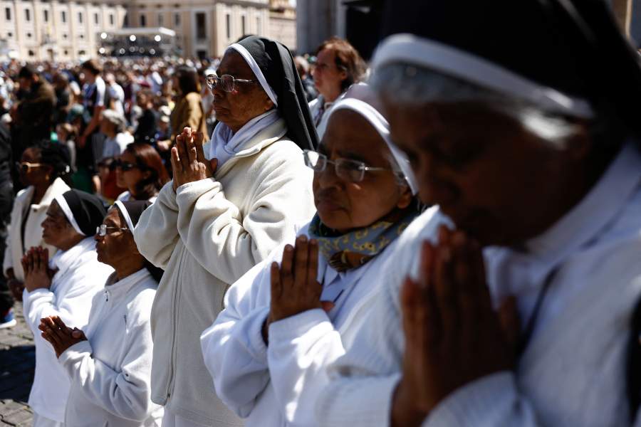 Монахини молятся во время траурной мессы Папы Франциска на площади Святого Петра в Ватикане.