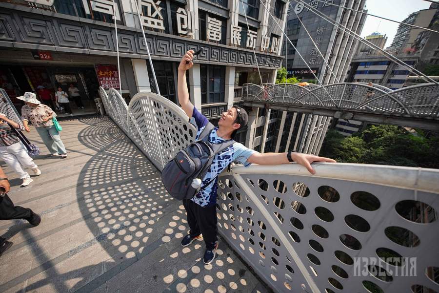 Сами китайцы с удовольствием фотографируются на фоне архитектурных особенностей Чунцина