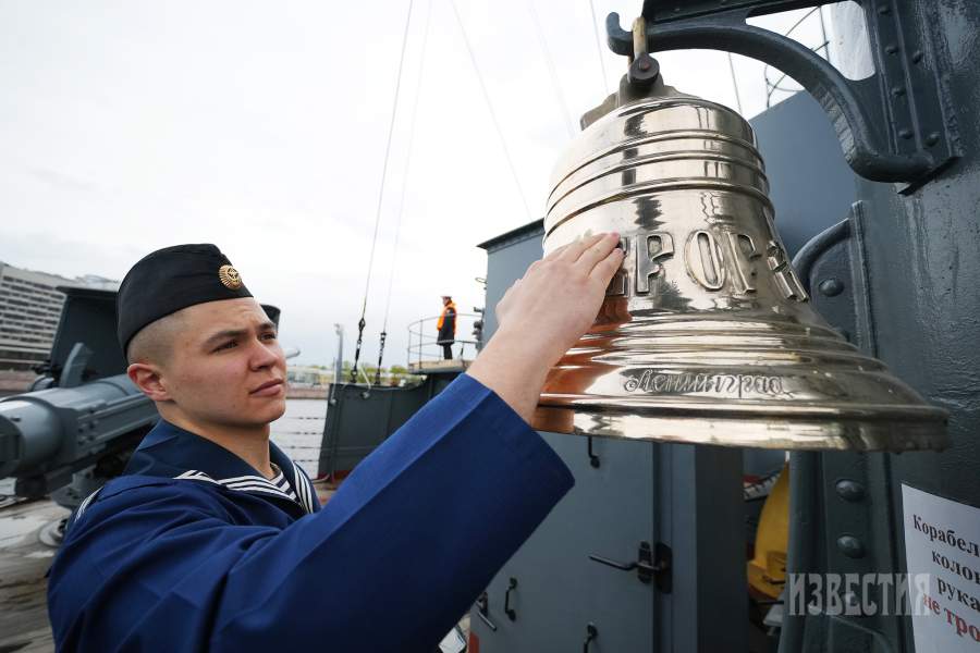 Россия. Санкт-Петербург. Матрос чистит корабельный колокол крейсера «Аврора».
