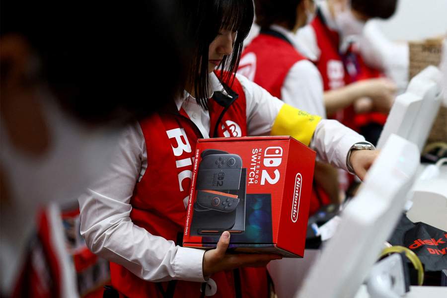 Сотрудник держит игровую консоль Nintendo Switch 2 в магазине электроники в Токио, Япония, 5 июня 2025 г., Nintendo начинает продажи новых консолей по всему миру