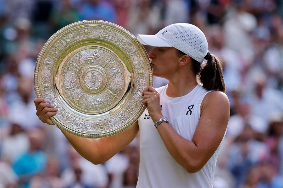 Tennis - Wimbledon - All England Lawn Tennis and Croquet Club, London, Britain - July 12, 2025 Poland's Iga Swiatek poses with the trophy after winning the women's singles final against Amanda Anisimova of the U.S.