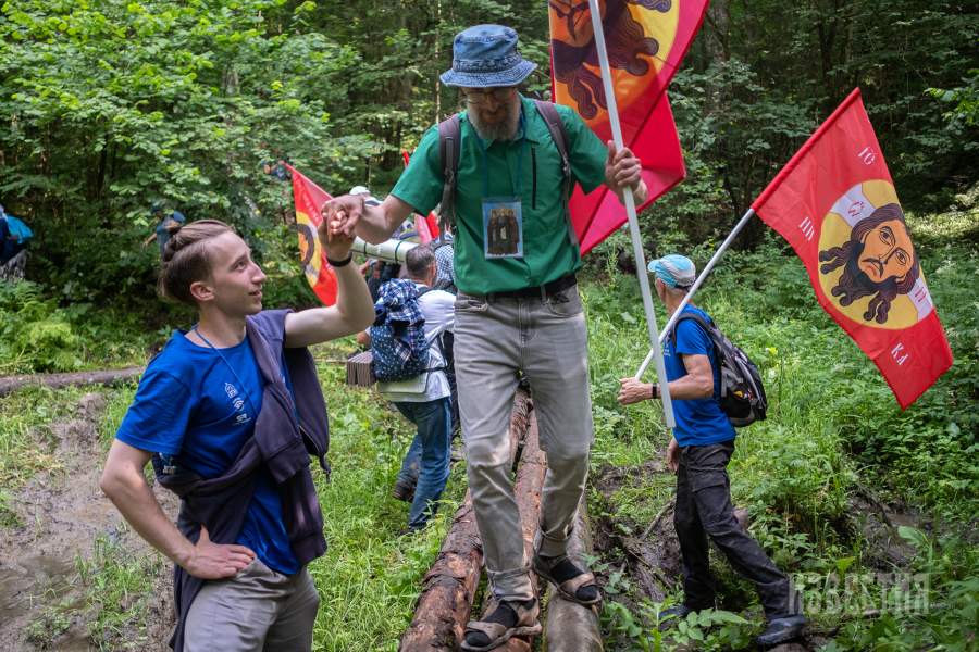 Помощь волонтеров и участников КХ в преодолении препятствий в лесу по ходу движения крестного хода