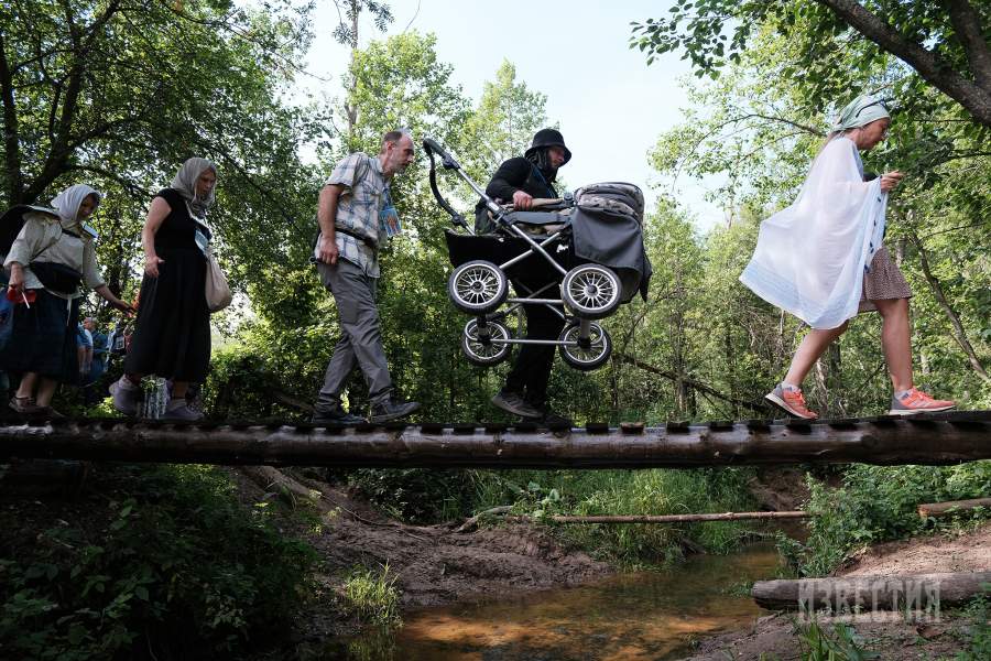 Переход участников крестного хода по мосту «Сумеречный», построенному волонтерами пешего маршрута «Дорога в лавру»