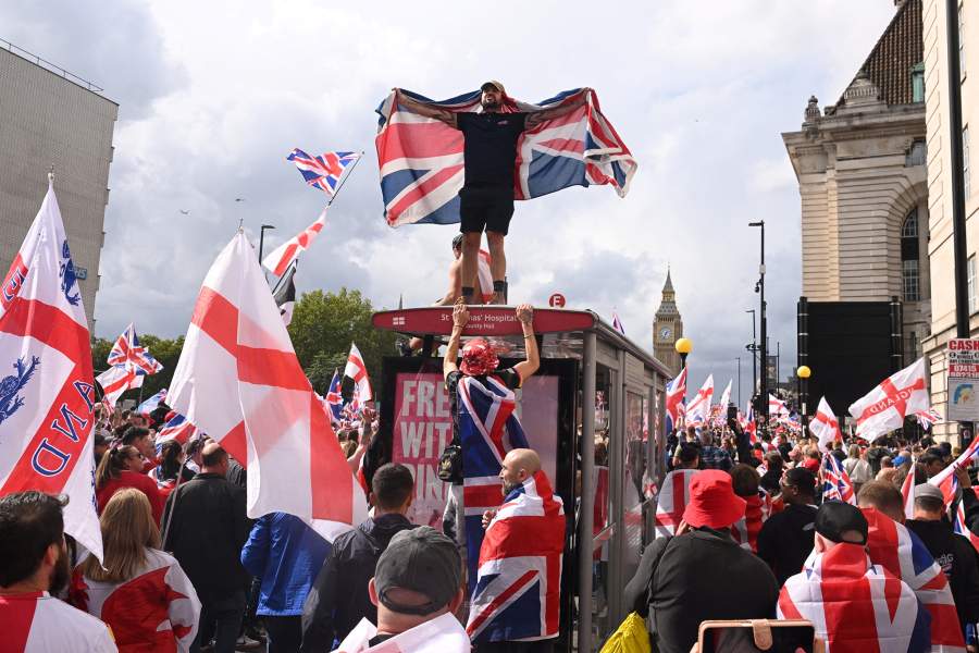 Протестующий стоит на автобусной остановке во время митинга в Лондоне 