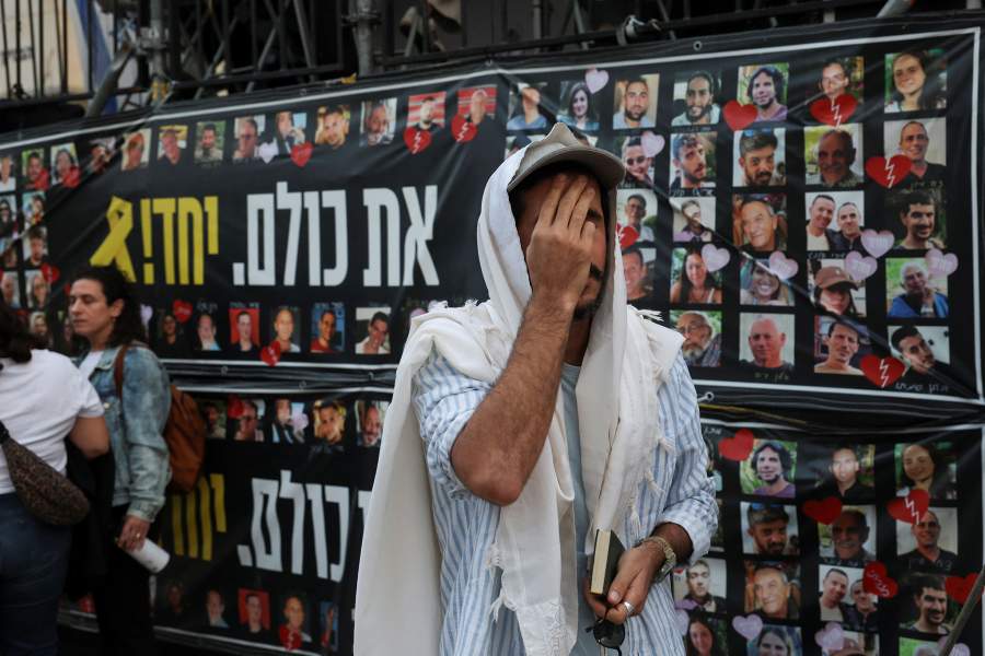 A man prays as people gather at "Hostages Square" to await the expected return of Israeli hostages, who have been held in Gaza since the deadly October 7, 2023 attack by Hamas, as part of a prisoner-hostage swap and a ceasefire deal between Israel and Hamas, in Tel Aviv, Israel, October 13, 2025