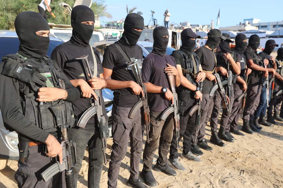 Palestinian militants stand guard on the day that hostages held in Gaza since the deadly October 7, 2023 attack, are handed over to the International Committee of the Red Cross (ICRC), as part of a ceasefire and hostages-prisoners swap deal between Hamas and Israel, in Khan Younis, southern Gaza Strip, October 13, 2025
