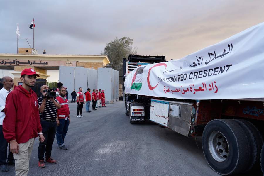 Egyptian Red Crecent members monitor trucks carrying humanitarian aid as they enter the Rafah crossing between Egypt and the Gaza Strip, following an agreement between Israel and Hamas on a ceasefire, Sunday, Oct. 12, 2025