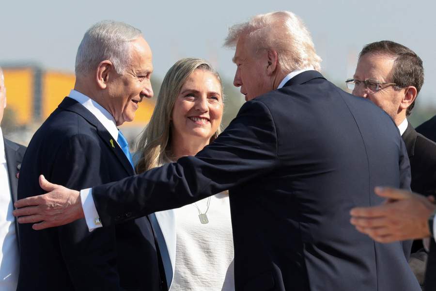 Israeli Prime Minister Benjamin Netanyahu reacts next to U.S. President Donald Trump at Ben Gurion International Airport, amid a U.S.-brokered prisoner-hostage swap and ceasefire deal between Israel and Hamas, in Lod, Israel, October 13, 2025