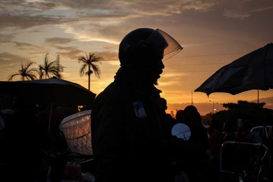 A motorcycle taxi rider, waits for clients during sunset in Douala, Cameroon, October 6, 2025. Though sometimes demonized by government officials who blame them for petty crime and disorder, "benskin" drivers say their plight encapsulates a bigger, more structural problem: lack of opportunity under President Paul Biya, who has ruled the Central African nation for more than four decades. "I am doing motorcycling 