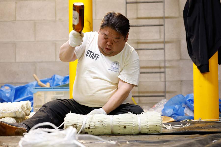 Sumo Wrestling - The Grand Sumo Tournament - Preview - Royal Albert Hall, London, Britain - October 12, 2025 A Yobidashi is seen making straw bales known as Tawara, inside the Royal Albert Hall, a centuries old technique rarely seen outside Japan. The tournament marks only the second time that Japan's iconic sport has visited the UK, following on from the previous event in 1991