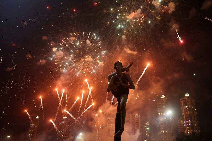 Девочка исполняет маллакхамб, традиционный индийский вид спорта, на фоне фейерверков, освещающих небо во время Дивали, индуистского фестиваля огней, в Мумбаи, Индия, 22 октября 2025 года 