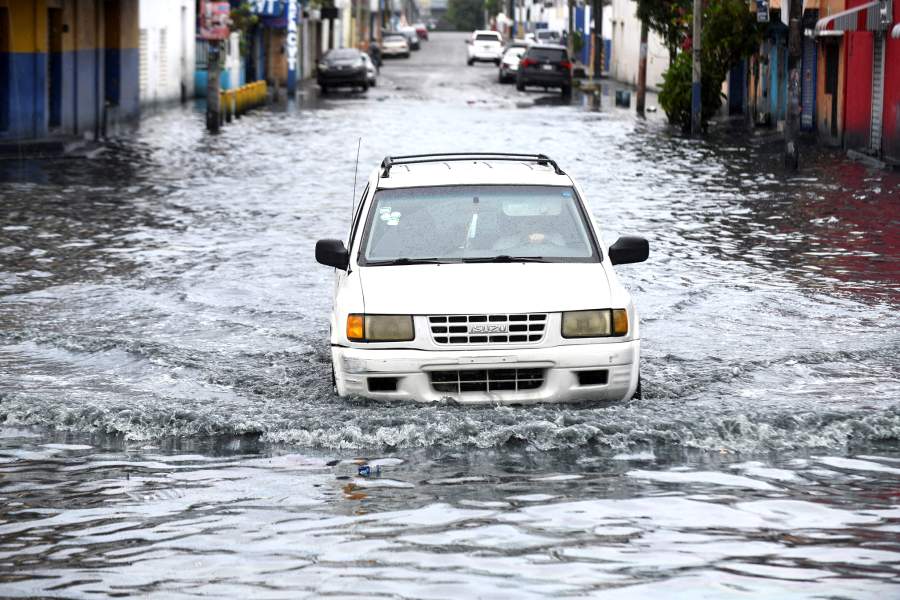 A vehicle transits along a street flooded by rains caused by Tropical Storm Melissa, in Santo Domingo, Dominican Republic