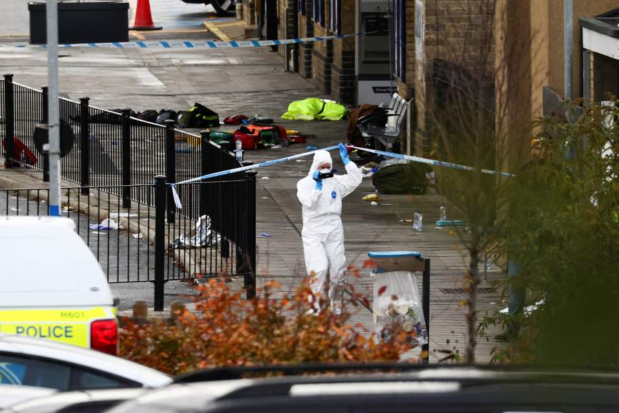 A forensic officer works at the scene at Huntingdon Station following a series of stabbings on a train, near Cambridge, Britain