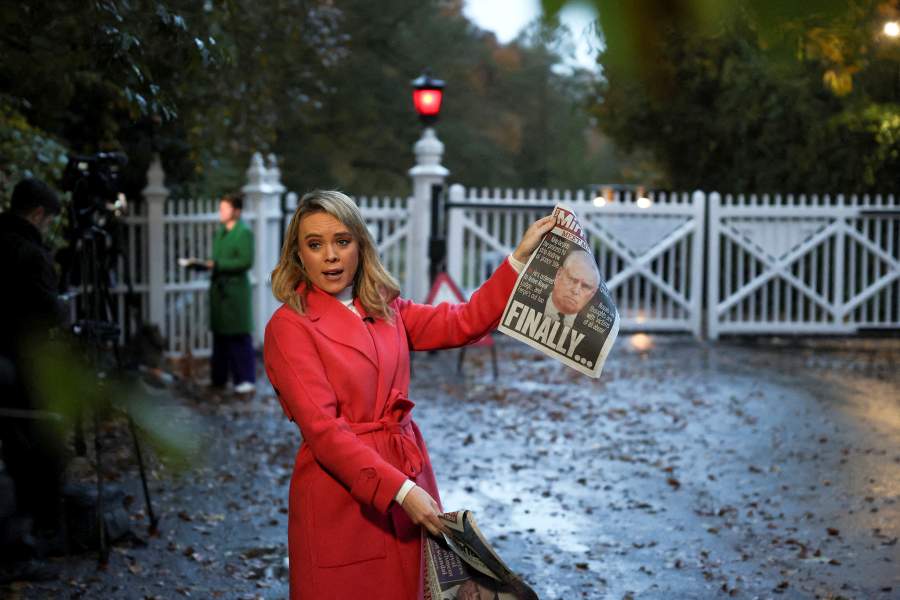 A member of the media shows the front page of a newspaper outside the entrance to the Royal Lodge, a large property on the estate surrounding Windsor Castle, where Andrew, the younger brother of Britain's King Charles lives, in Windsor, Britain