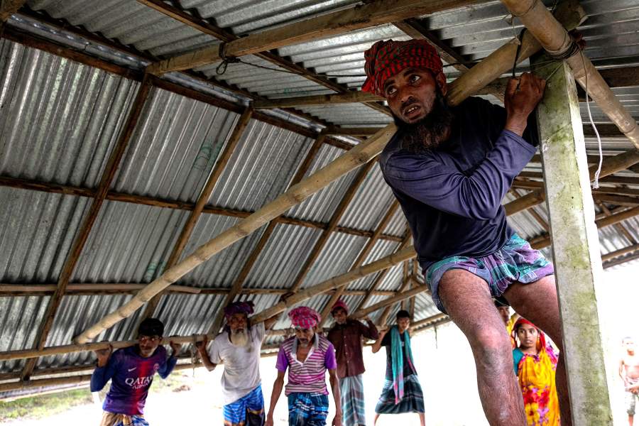 Relatives and neighbours help move the house of Kosim Uddin, 50, to another island in the Brahmaputra River, as the current one is on the verge of being destroyed by erosion, in Kurigram, Bangladesh, June 20, 2024.