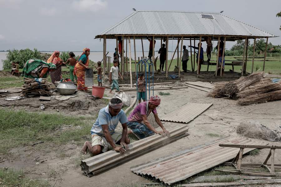 Relatives and neighbours help move the house of Kosim Uddin, 50, to another island on the Brahmaputra river, as the current one is about to be destroyed by erosion, in Kurigram, Bangladesh, June 20, 2024. REUTERS/Mohammad Ponir Hossain