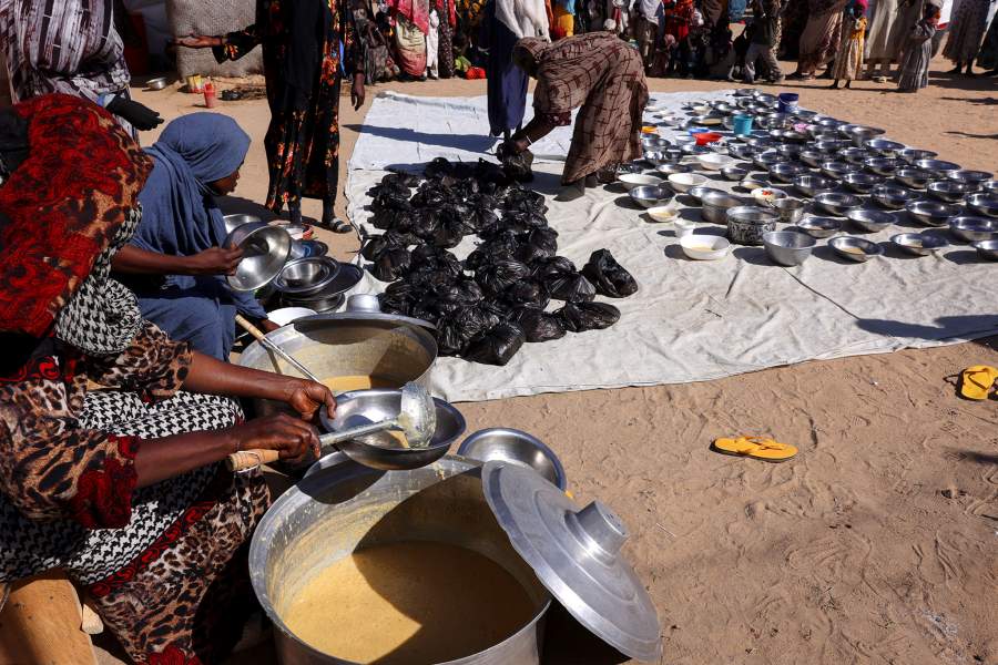 Sudanese refugees from al-Fashir, displaced by ongoing clashes between the paramilitary Rapid Support Forces (RSF) and the Sudanese army, arrange free meals of barley and bread provided by the Civilian Network for Justice, with support from the Strategic Initiative for Women in the Horn of Africa (SIHA) Network, at the Tine transit camp in eastern Chad, November 23, 2025. REUTERS/Amr Abdallah Dalsh