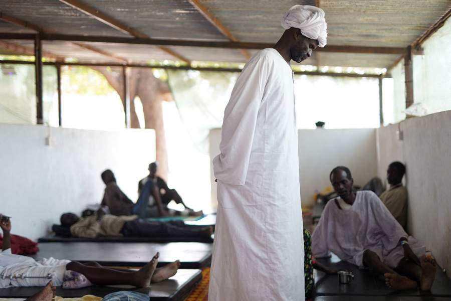 A man walks next to injured displaced Sudanese people, who fled violence in al-Fashir, and are receiving treatment at a makeshift clinic run by Medecins Sans Frontieres (MSF), amid ongoing clashes between the paramilitary Rapid Support Forces (RSF) and the Sudanese army, in Tawila, North Darfur, Sudan November 3, 2025. REUTERS/Mohamed Jamal