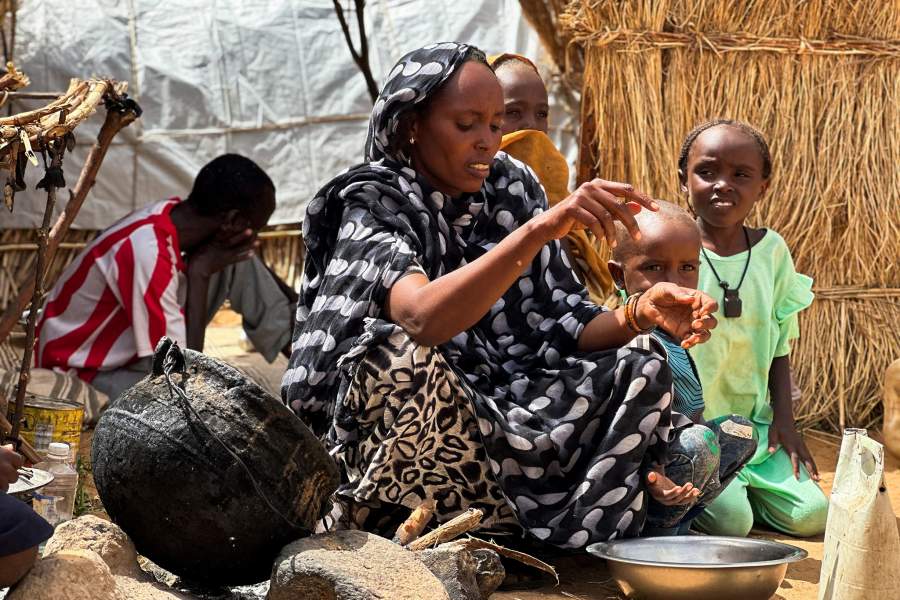 FILE PHOTO: Houda Ali Mohammed, 32, a displaced Sudanese mother of four, prepares food at a camp shelter amid the ongoing conflict between the paramilitary Rapid Support Forces (RSF) and the Sudanese army, in Tawila, North Darfur, Sudan, July 30, 2025. REUTERS/Mohamed Jamal/File Photo
