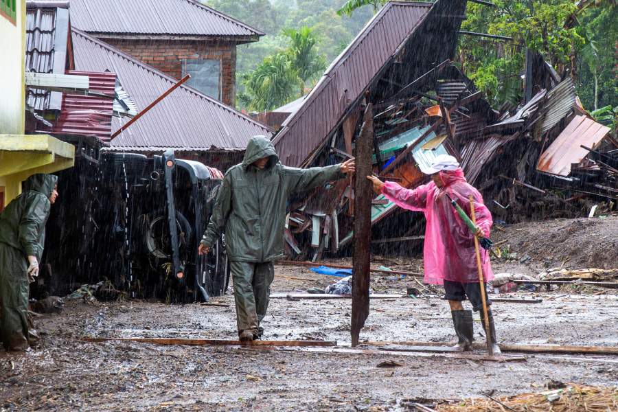 Residents remove debris from an area hit by deadly flash floods following heavy rains in Malalak, Agam regency, West Sumatra province, Indonesia