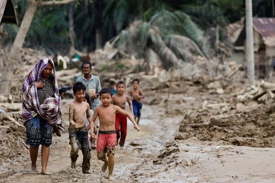 Выжившие идут по территории, пострадавшей от смертоносного наводнения после проливных дождей в Каранг-Бару, округ Ачех-Тамианг, провинция Ачех, Индонезия, 6 декабря 2025 года