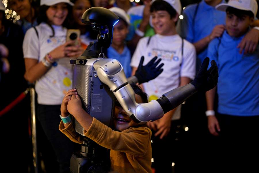 A child hugs a robot in the La Carlota convention center during the inauguration of a space-themed children's exhibition on the solar system, in Caracas, Venezuela
