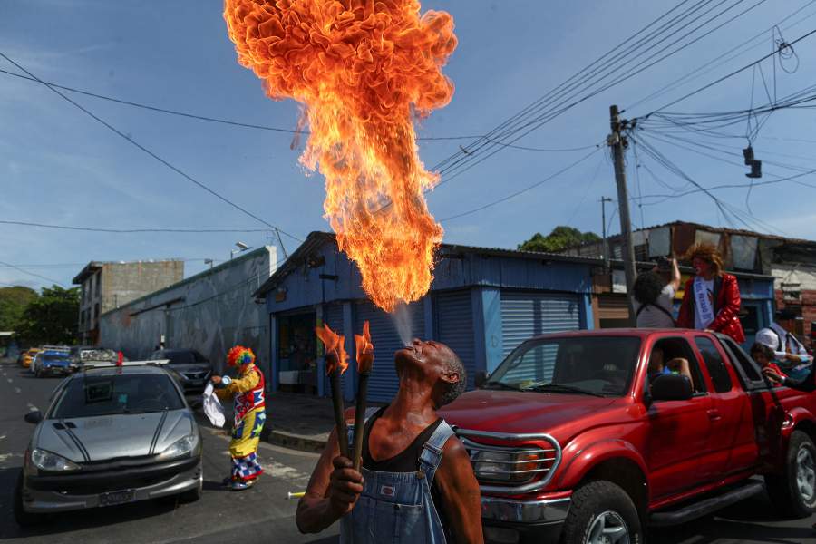 A performer spits fire during a parade marking National Clown Day in San Salvador, El Salvador, December 3