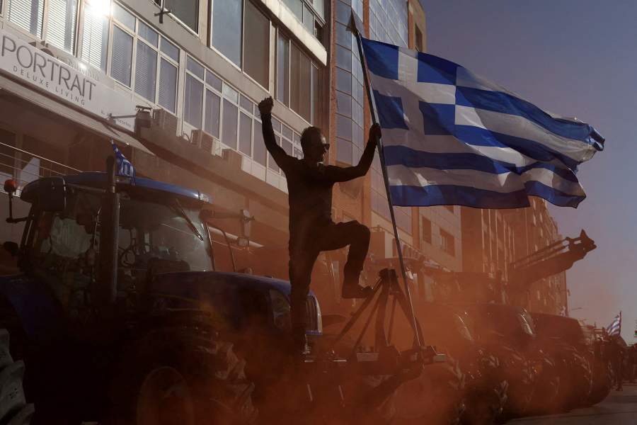 A farmer holds a Greek flag, while protesting at the entrance to the city's port, over delays in payments of European Union subsidies, in Thessaloniki, Greece, December 12, 2025