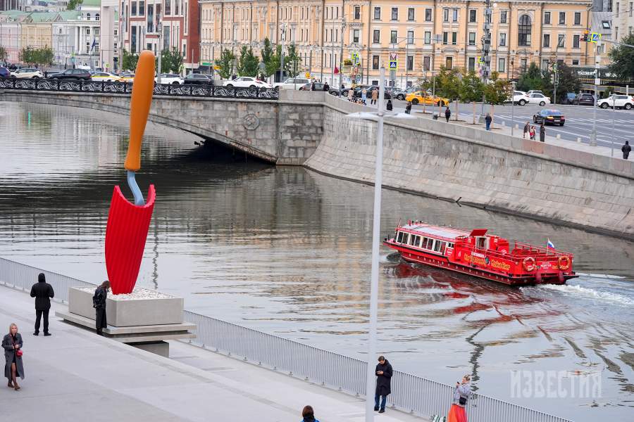Люди около красной версии скульптуры «Садовая лопатка» Класа Олденбурга и Кошье ван Брюгген у Дома культуры «ГЭС-2» на Болотной набережной