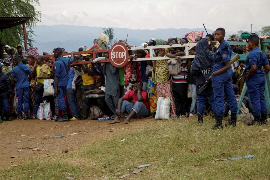 Congolese civilians stand by a barrier at a reception center in Gatumba, a police camp near the border post that temporarily shelters people who fled renewed tensions between M23 rebels and the Armed Forces of the Democratic Republic of the Congo (FARDC), in Gatumba, Burundi, December 11, 2025. REUTERS/Evrard Ngendakumana TPX IMAGES OF THE DAY