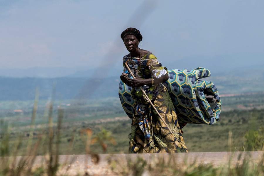 A Congolese woman displaced during renewed clashes between Alliance Fleuve Congo AFC/M23 and the Armed Forces of the Democratic Republic of the Congo (FARDC), carries a mattress as she returns to her home from Sange, in Luvungi, a settlement north of Uvira, South Kivu province, in the Democratic Republic of Congo, December 13, 2025. REUTERS/Stringer