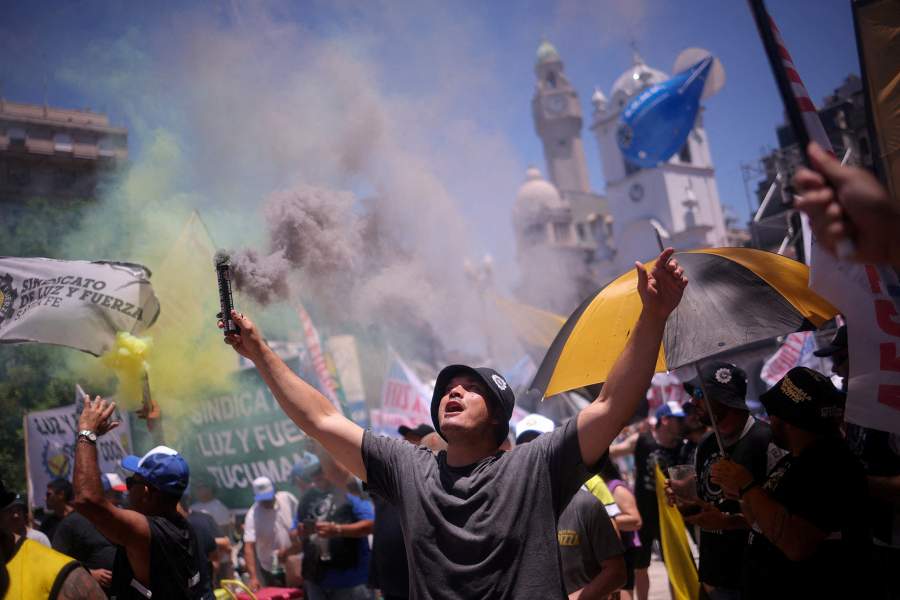 A demonstrator holds a smoke flare, during a protest organised by Argentina's General Confederation of Labor (CGT) against the government's proposed labour law reform, at Plaza de Mayo in Buenos Aires, Argentina, December 18, 2025
