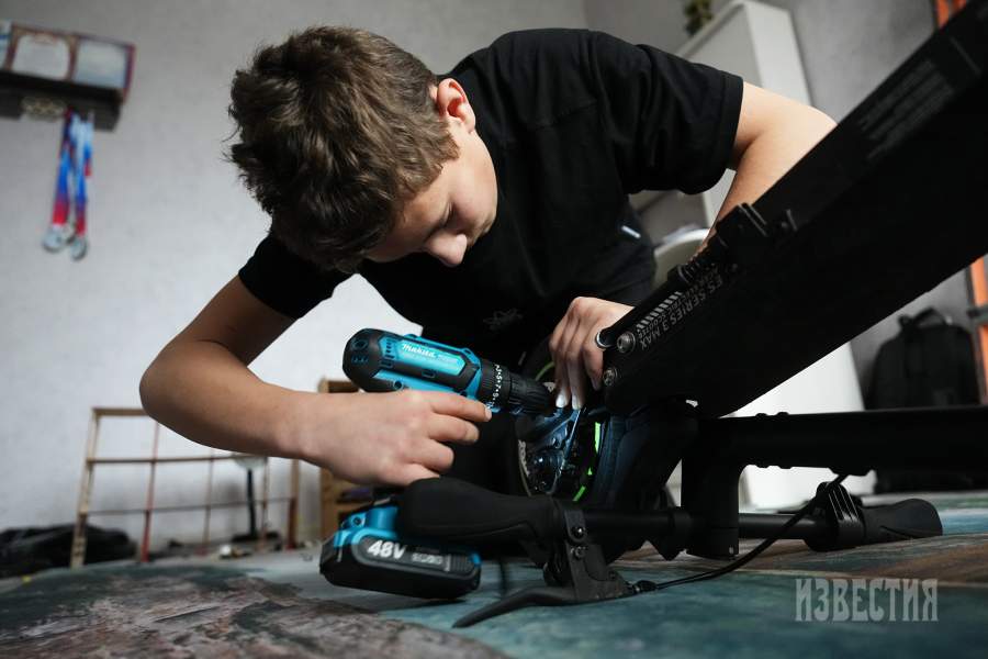 Подросток ремонтирует электросамокат