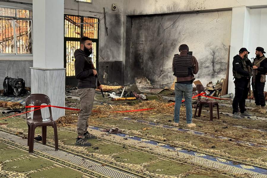 Syrian security forces stand inside a damaged mosque after several people were killed in an explosion at a mosque of the Alawite minority sect, as a Syrian Arab News Agency (SANA) said, in Homs, Syria December 26, 2025. REUTERS/Ali Ahmed al-Najjar NO RESALES. NO ARCHIVES