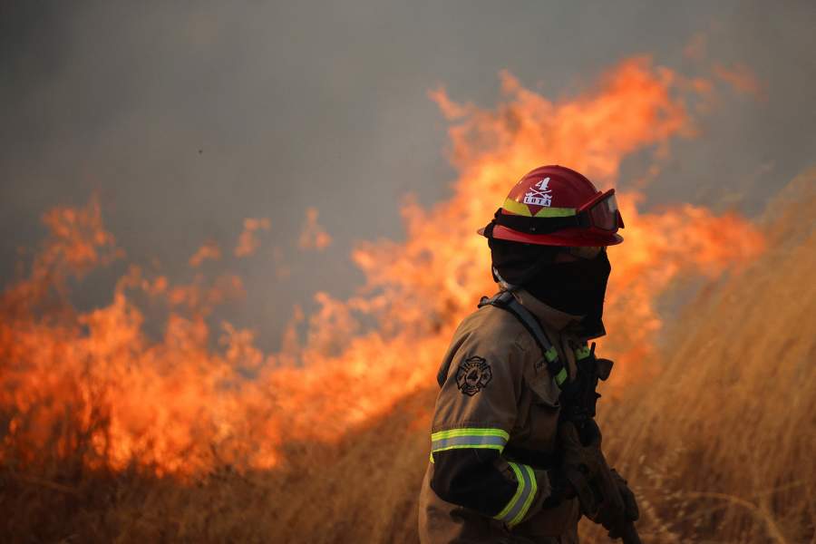 A firefighter looks on as a fire burns in the Biobio region, where multiple wildfires have prompted emergency evacuations, in Florida, Chile, January 21, 2026