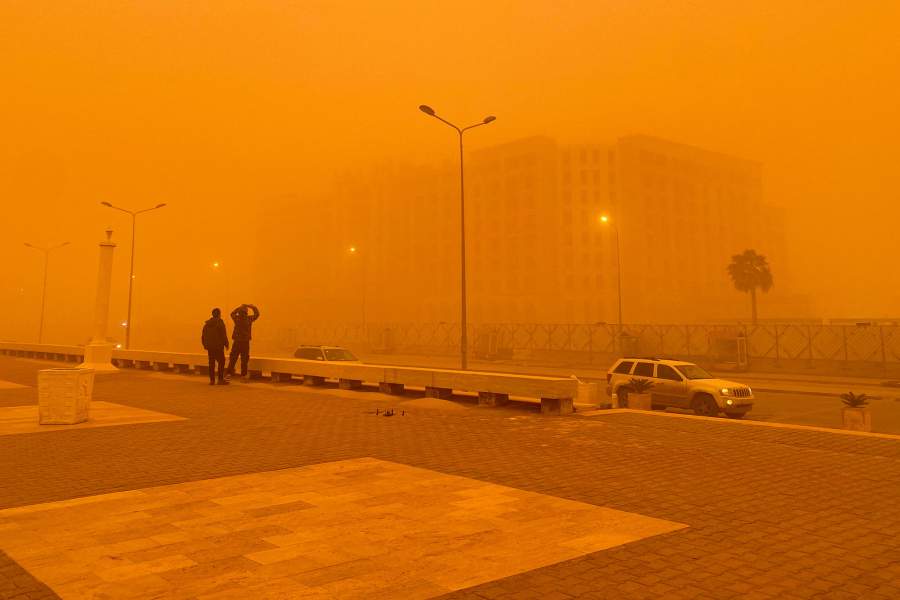 A man takes a picture of a building during a dust storm in Benghazi, Libya, January 20, 2026